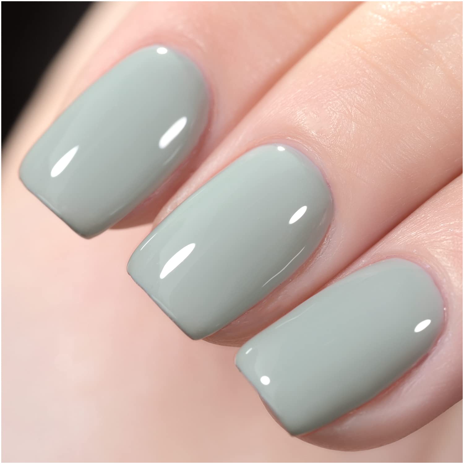 Female hand with green nail design. Light green glitter nail polish manicure  on green fabric Stock Photo | Adobe Stock