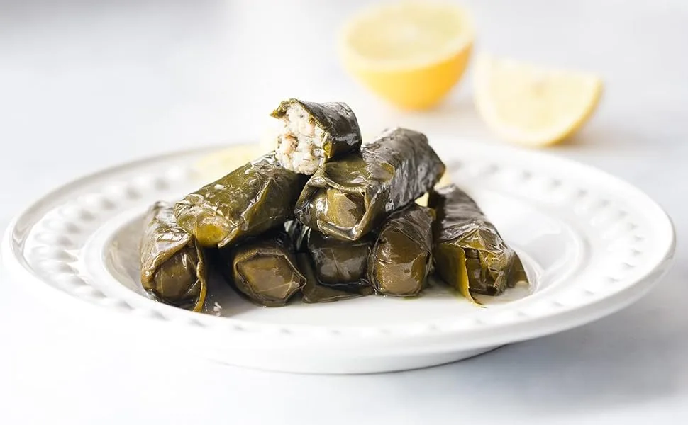 Odysea Stuffed Vine Leaves 310g - vine leaves on plate with lemon