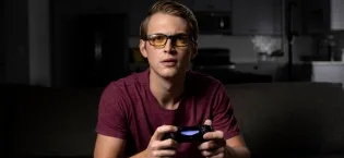 Gunnar gaming and computer glasses - ESL blade - blue light filter glasses premium blue filter UV protection Onyx ' - Lens: Amber (65% Blue Light Protection) amber - guy playing videogames wearing the Vertex glasses