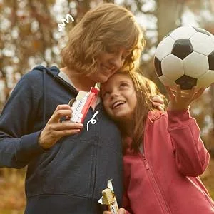 Protein Bar Chocolate - Woman hugging young girl holding a soccer ball both eating power crunch bars