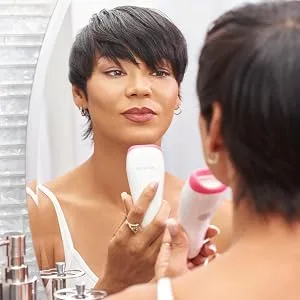 JuvaLips | Original White Lip Plumping Device & Plumping Serum | Made in the USA - Woman looking in the mirror admiring her plumper lips