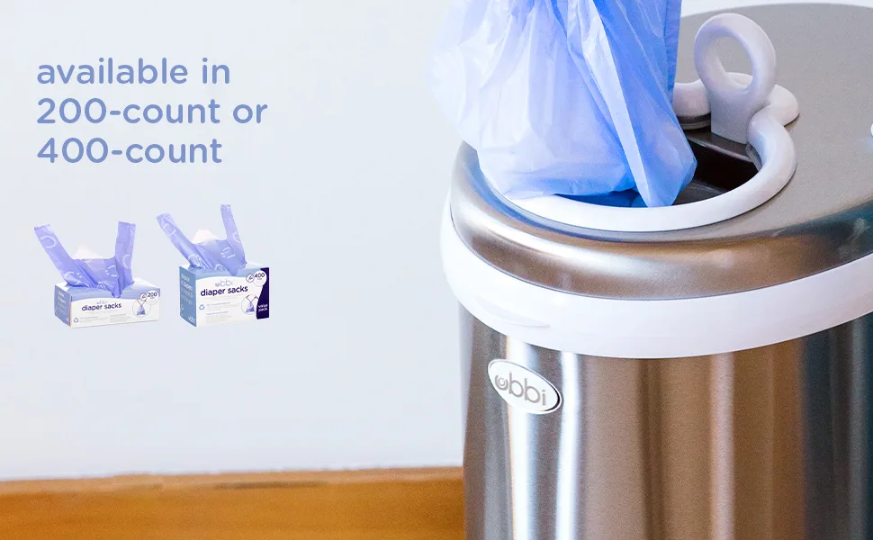 Ubbi Disposable Diaper Sacks Lavender Scented Easy-To-Tie Tabs Diaper Disposal or Pet Waste Bags 200 Count 200 Count (Pack of 1) - Available in 200-count or 400-count. A diaper sack is being dropped into a chrome Ubbi diaper pail
