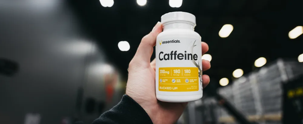 Bucked Up Caffeine 200mg Per Serving Essentials (180 Servings 180 Capsules) - Man holding Bucked Up Caffeine bottle in hand