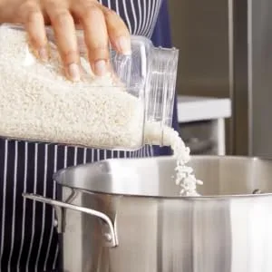 RiceSelect Arborio Rice for Italian Risotto, Premium Gluten Free Rice, Non-GMO, 32 Ounce Jar - Pouring arborio rice into a pot to make risotto