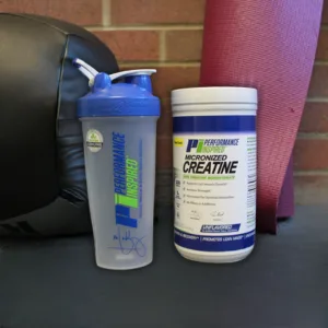 Performance Inspired Nutrition Unflavored Micronized Creatine 1.1 Oz - Creatine with Blender bottle with medicine ball and yoga mat in back