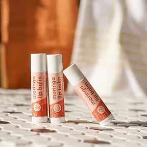 True Moringa Lip Balm - Intense Hydration & Relief for Dry Chapped Lips with Moringa and Shea Butter - 100% vegan paraben free sulfate free ethically sourced - 3 moringa balms leaning against each other