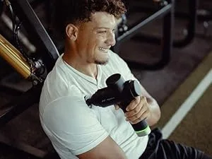 Hyperice Hypervolt Go 2 in Black - Featuring Quiet Glide Technology - Handheld Percussion Massage Gun | 3 Speeds 2 Interchangeable Heads | Helps Relieve Sore Muscles and Stiffness | FSA-HSA Eligible Hypervolt Go 2 Black - Patrick Mahomes in a gym using a Hypervolt 2 Pro on his shoulder.