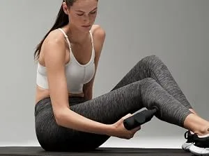 Hyperice Hypervolt Go 2 in Black - Featuring Quiet Glide Technology - Handheld Percussion Massage Gun | 3 Speeds 2 Interchangeable Heads | Helps Relieve Sore Muscles and Stiffness | FSA-HSA Eligible Hypervolt Go 2 Black - Woman in a jogging outfit putting a Hypervolt Go 2 into a backpack.