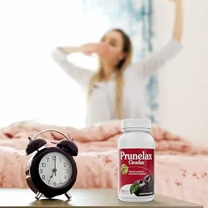 Prunelax Tablets, 150 Count - woman waking up on time with a prunelax bottle and alarm clock