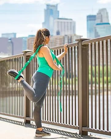 OPTP Franklin Textured Ball Set - 2 Inflatable Exercise Balls (LE9001) - woman standing on bridge using stretch out strap staring at minneapolis skyline