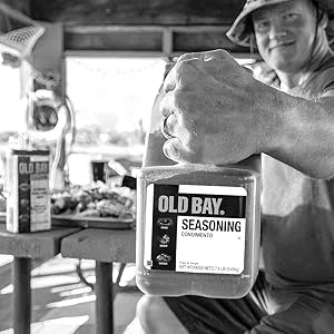 OLD BAY Cocktail Sauce, 8 fl oz - Crabber holding up big container of Original Old Bay Seasoning