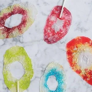JOLLY RANCHER Gummies Assorted Fruit Flavored Candy Bag 7 oz Original Flavors 7 Ounce (Pack of 1) - Melted Jolly Rancher hard candy lollipop sticks on a counter top