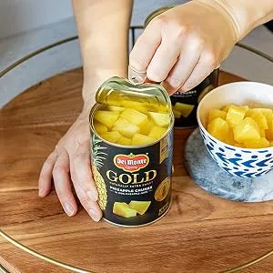 DEL MONTE DELUXE GOLD Pineapple Chunks in 100% Pineapple Juice, Canned Fruit, 20 oz Can - A person opening Del Monte Pineapple can