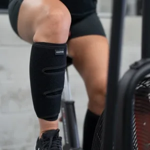 Calf Support Brace 2 Pack, Adjustable Shin Splint Compression Calf Wrap - Woman riding exercize bike while wearing Calf Support Braces