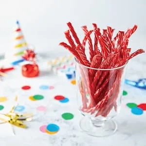 Twizzlers & Jolly Rancher Misfit Gummies - Assorted Gummy Candy & Licorice Holiday Candy Bulk Candy Individually Wrapped Candy To Share Candy for Kids - 160ct 1.9kg - A glass container filled with Twizzlers candy in a birthday party setting
