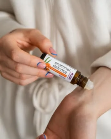 NOW Solutions Magnesium Topical Spray from the Ancient Zechstein Seabed Highly Concentrated 237ml - NOW Essential Oil roll on being applied to womans wrist