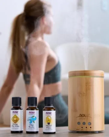NOW Solutions Magnesium Topical Spray from the Ancient Zechstein Seabed Highly Concentrated 237ml - NOW essential oils and diffuser with woman practicing yoga in background