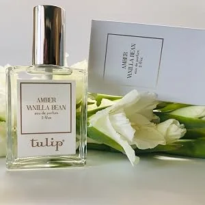 Tulip Amber Vanilla Bean Eau de Parfum - Amber Vanilla Bean Bottle with box tilted and white flowers
