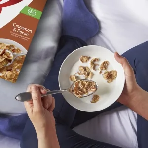 Kelloggs Corn Pops Breakfast Cereal, 8 Vitamins and Minerals, Kids Snacks, Large Size, Original, 14.6oz Box (1 Box) - Enjoy cereal with milk at night as a treat like this young woman in leggings relaxing on her bed