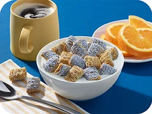 Kellogg's Frosted Mini-Wheats Cold Breakfast Cereal, High-Fiber, Whole Grain, Original, 18oz Box (1 Box) - breakfast table with a bowl of blueberry frosted mini wheats, sliced oranges, and cup of coffee