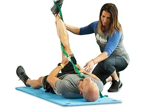 OPTP The Original Stretch Out Strap with Exercise Poster  Made in The USA Stretching Strap and Yoga Strap for Stretching, Physical Therapy Exercise and Flexibility - man using stretch out strap while woman helps him
