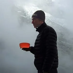 SEATO SUMMIT BOL Delta Azul Pacific Blue - Man holding an orange Delta Bowl near ice.