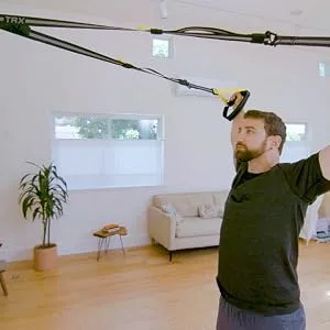TRX Training Invizi-Mount Wall Anchor V2 Suspension Training Kit, Training Club App INVIZI-MOUNT 2 - A man using wall-mounted exercise equipment. Image 6 Text: For All Fitness Levels