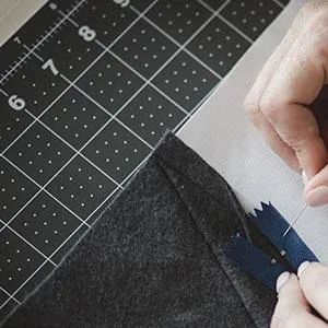 Fiskars Craft Supplies: Self Healing Cutting Mat for Crafts, Sewing, and Quilting Projects, 24x36 (12-83727097J) , Gray Home - Person working on a sewing project with the self heeling mat