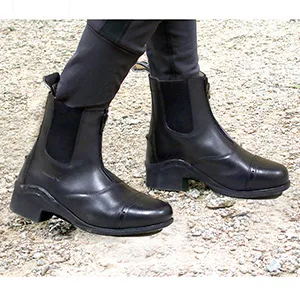 One Stop Equine Shop BasEQ Nora Leather Childrens Zip Up Paddock Boot 1 Big Kid Black - Image from the left side of a pair of feet wearing the Nora boots while walking on gravel.