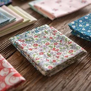Connecting Threads Print Collection Precut 100% Cotton Quilting Fabric Bundle Fat Quarter (Hello Daisy) - precut fabric pieces with different floral patterns lay on a wood table