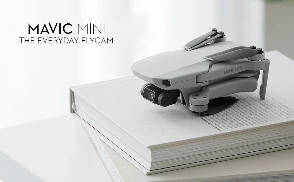 DJI Mavic Mini Combo Drone FlyCam Quadcopter with 2.7K Camera 3-Axis Gimbal GPS 30min Flight Time (Renewed) - Mavic Mini in folded position on top of book