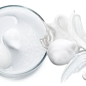 KLAPP Cosmetics Triple Action Glow Peeling AHA + BHA 30ml - Close-up van heldere vloeistofdruppels of gel op een reflecterend oppervlak, met een witte romige substantie op de achtergrond