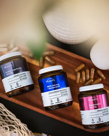 NMM Sp z oo Vitalers Creatine Monohydrate Bioavailable micronized 200 mesh highly soluble 100 pure powder without additives vegan 500 g 100 servings 500 g lemon - Drie supplementflessen op houten dienblad. Bruine, blauwe en roze labels. Witte keramische schalen en geweven materiaal zichtbaar. De capsules zijn verspreid over het oppervlak van de schaal.