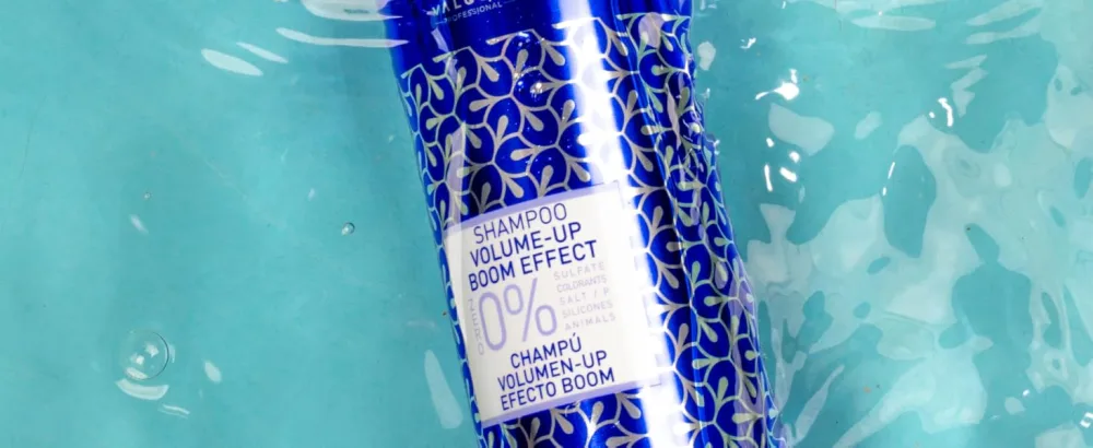 Valquer Laboratorios V lquer Shampoo VolumeUp Boom Effect 400 ml - Blauwe fles voor cosmetische producten met geometrisch patroonontwerp dat in turkoois water drijft, waardoor een verfrissende productpresentatie ontstaat.