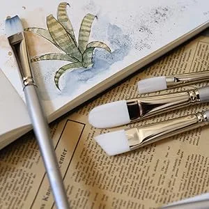 Silver Brush Limited 1504S6 Silverwhite Fan Brush  Watercolor  Acrylics  Gouache or Oil Brush  Size 6  Short Handle - Paintbrushes lying on a table next to an open sketchbook with a small painting of a plant in it.