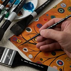 Silver Brush Limited 3007S1 Black Velvet Script Liner Watercolor Paint Brush  Size 1  Short Handle Size - 1 - A hand painting using a fine-tipped brush and surrounded by brushes and art supplies.