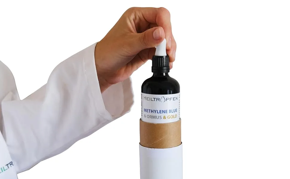 Methylene Blue & Ormus & Gold 3.4 Fl Oz - 100 ml | Ultra High Purity | with 10 ppm Colloidal Gold 24K | Glass Bottle | Third-Party Tested | Heiltropfen  - Hand pulling from cardboard tube Heiltropfen Ormus Gold Methylene Blue dropper for research use.