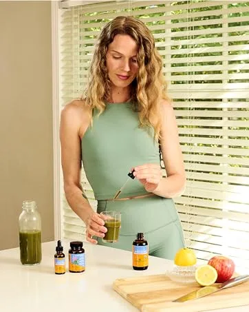 Herb Pharm Urinary System Support Liquid Herbal Formula - 4 Ounce 4 Fl Oz (Pack of 1) - Woman mixing green drink with dropper beside herbs, lemon, apple, and Herb Pharm supplements.