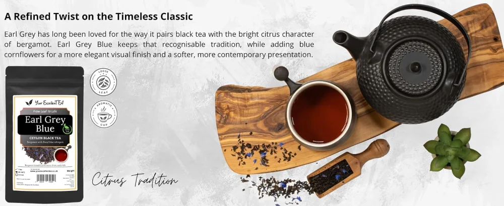 Your ExcellenTEA Earl Grey Blue Loose Leaf Black Tea Bergamot Ceylon Black Tea with Cornflower Petals Floral Earl Grey Blend - 250g  - Text reads "A Refined Twist on the Timeless Classic" and "Cozy Tradition". Overhead view of black teapot with tea cup on wooden board, tea leaves, star anise, and cinnamon stick arranged on white surface. Product packaging visible on left.