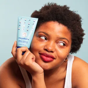 Megababe Sweat Absorbing Lotion - Magic Powder Stay-Dry Lotion Potion | Aluminum-Free  Talc-Free | 4.5 fl oz - Magic powder being held up.