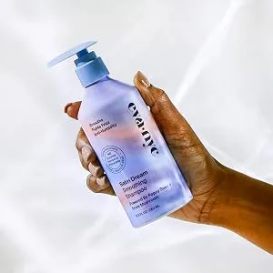 Eva NYC Satin Dream Smoothing Shampoo  8.8 oz - Hand holding blue +pink shampoo bottle
