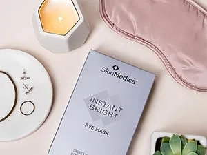 SkinMedica HA5 Rejuvenating Hydrator  2 Oz 2 Ounce (Pack of 1) - eye mask on cream colored table with a candle, silk eye mask, plant next to it.