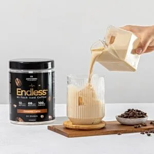 Protein Works - Endless Coffee | for Brain and Cognitive Support | Zero Crash No Added Sugar | Caramel Latte - 460g - pouring endless coffee from a carton into the glass with ice