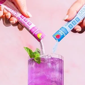 Ultima Replenisher Electrolyte Hydration Powder Variety Pack 20 Count Stickpacks - Someone pouring two stickpacks into their drink